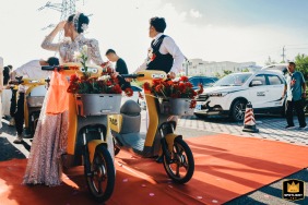 In Kaifeng, Henan, China, the bride and groom prepare to use shared electric bicycles as their unconventional "flower car," setting off for the reception hotel.
